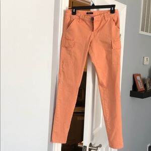 Peach colored ankle jeans.